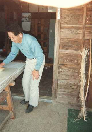 Mr Fukunishi brushes the paper onto the drying board